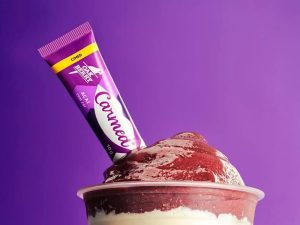 Copo de açaí Oakberry com bisnaga Carmed sabor açaí, fruto de collab entre Cimed e Oakberry.